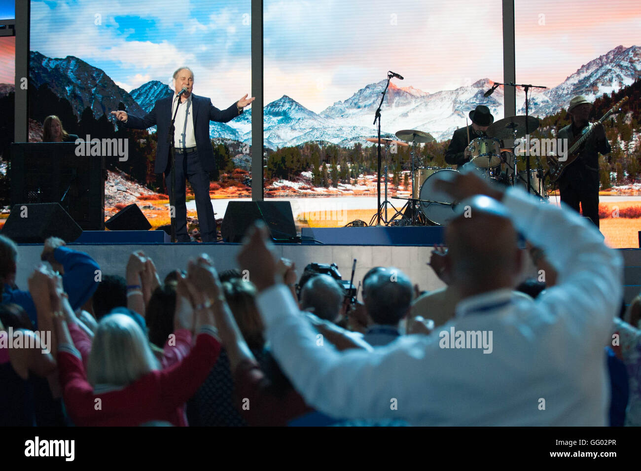 2016 Convenzione Nazionale Democratica delegati unire le mani e ondeggiano avanti e indietro mentre la rock star Paul Simon esegue il ponte sopra l'acqua disturbata a Wells Fargo center di Filadelfia in Pennsylvania Stati Uniti d'America | Foto Stock