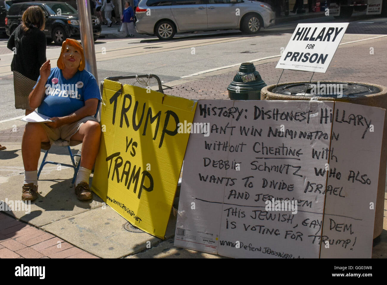 Un uomo con un Hillary Clinton proteste di maschera la sua candidatura al di fuori del Philadelphia Convention Center Foto Stock