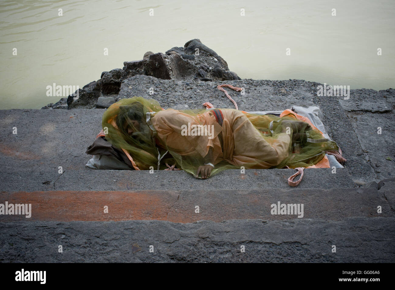 Rishikesh, Uttarakhand, India. Il 17 maggio 2013. File immagine - un Sadhu coperti da una zanzariera poggia sulla rive del fiume Gange a Rishikesh, Uttarakhand, India. Nota per i redattori: Questa immagine appartiene ad un lavoro personale che è stato girato su 2013 lungo l'Iran, la Turchia e l'India denominato ''Il Passeggero - Foto perso' © Jordi Boixareu/ZUMA filo/Alamy Live News Foto Stock