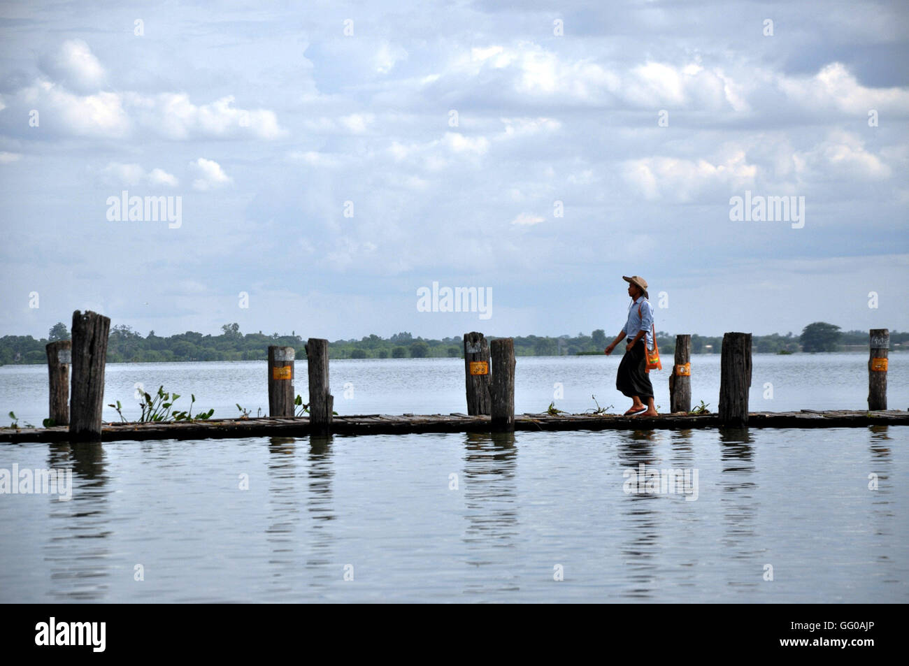 (160803) -- MANDALAY (Myanmar), 3 Agosto, 2016 (Xinhua) -- Un uomo cammina sulla U Pein bridge a Mandalay, Myanmar, il 3 agosto, 2016. L'U Pein ponte che attraversa il lago Taungthaman vicino Amarapura, sud del Mandalay in Myanmar, ha visto nessun patroni di cammino da un lato all'altro del ritardo, come il più lungo ponte nella regione è a rischio di essere sommerso come livelli di acqua sono aumentati a livelli pericolosi. (Xinhua/Hou Baoqiang) (lr) Foto Stock