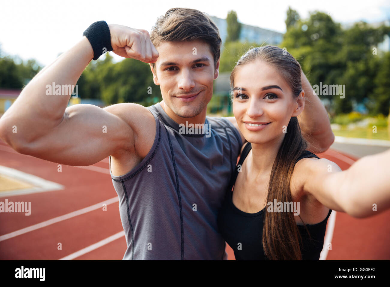 Giovani happy sport giovane rendendo selfie foto sul Stadium, l uomo che mostra bicipite Foto Stock