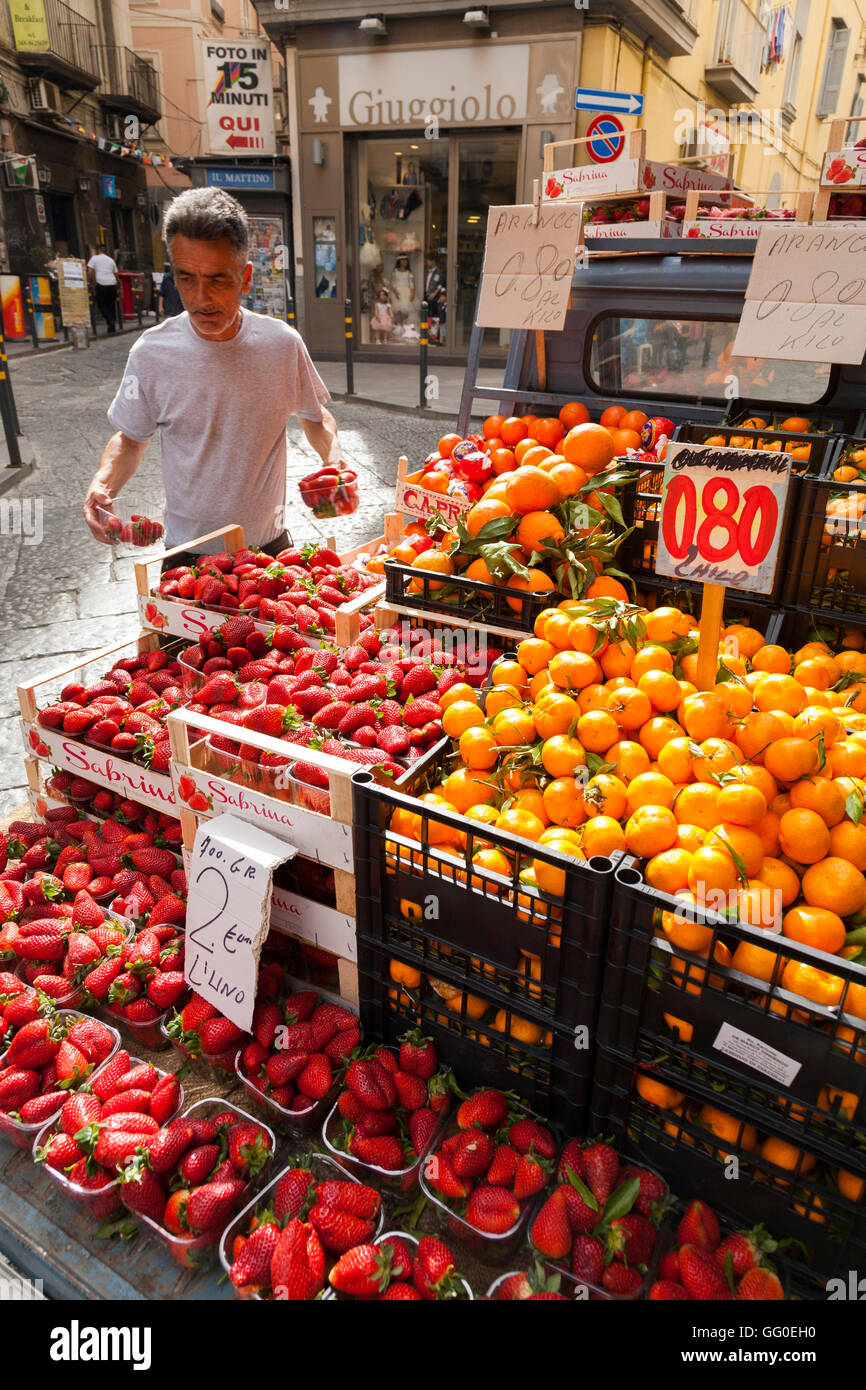 Italian street market venditore con la sua altissima qualità frutta fresca - Fragole & arance - e verdure, stallo napoli, Italia Foto Stock