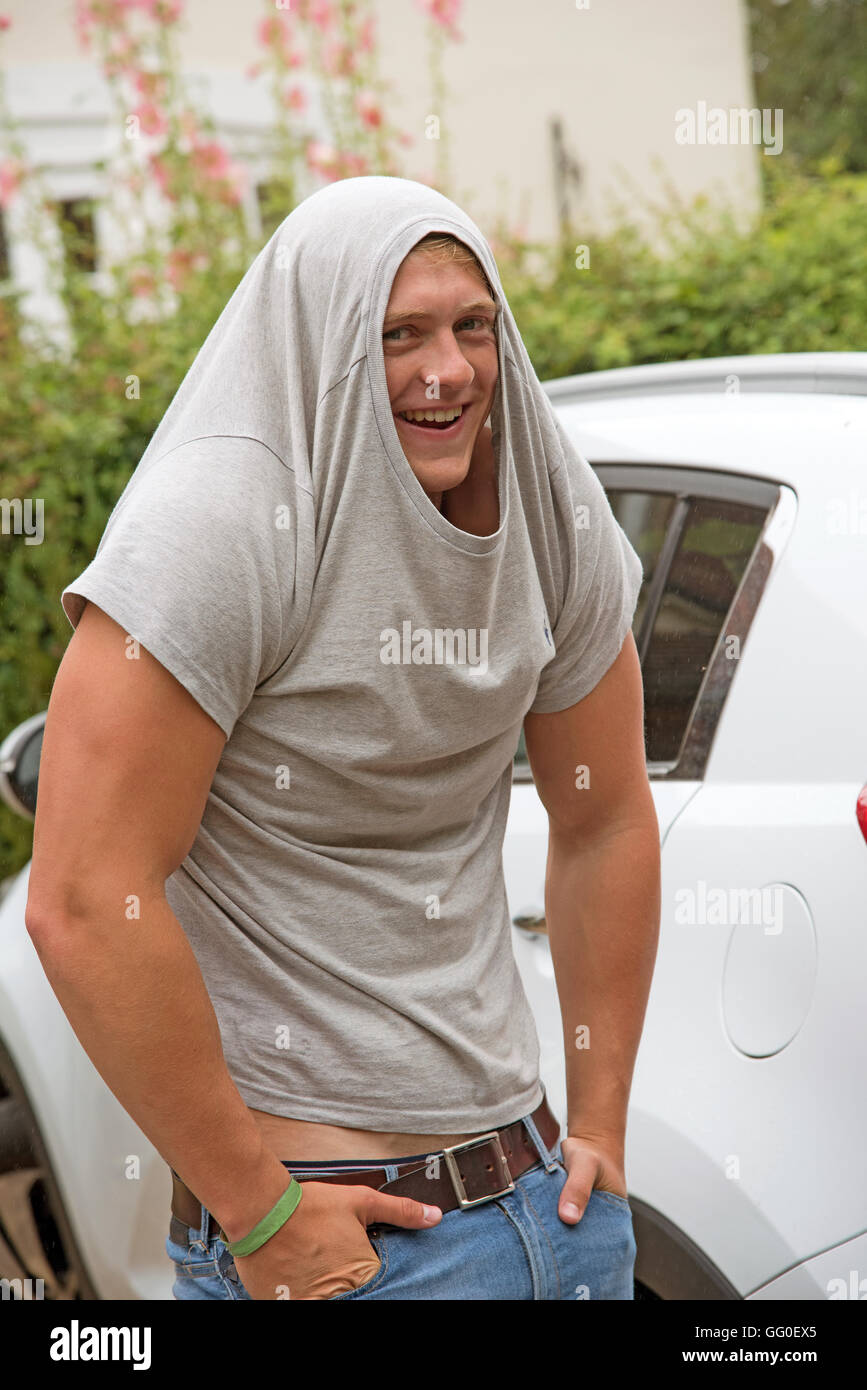 Giovane uomo che indossa un maglione sopra la sua testa Foto Stock