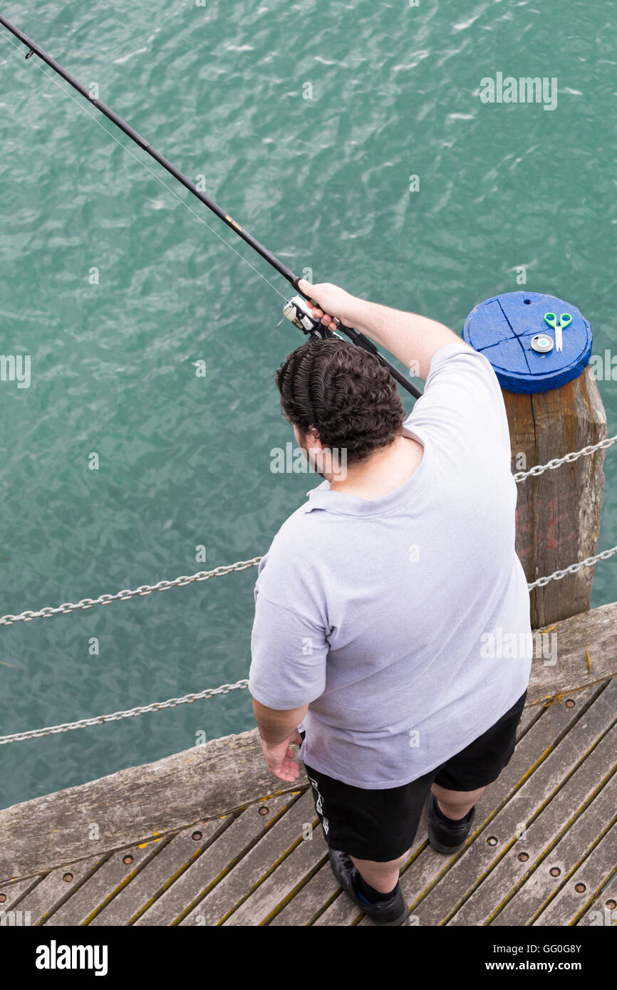 Guardando verso il basso sulla pesca uomo a Swanage Pier in luglio Foto Stock