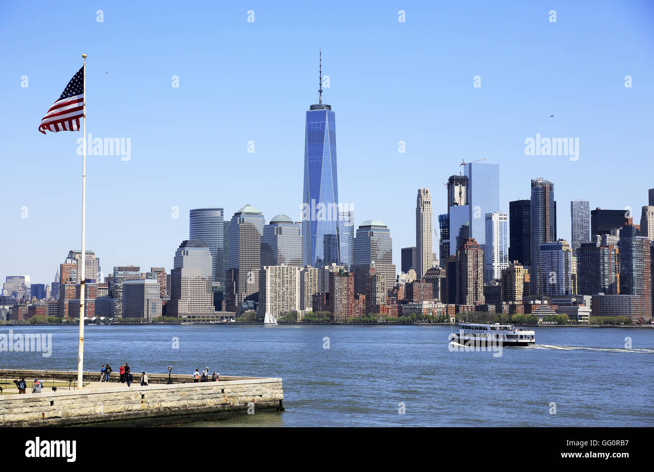 Skyline di Manhattan il quartiere finanziario della città di New York con una bandiera degli Stati Uniti su Liberty Island in primo piano.New York,USA Foto Stock