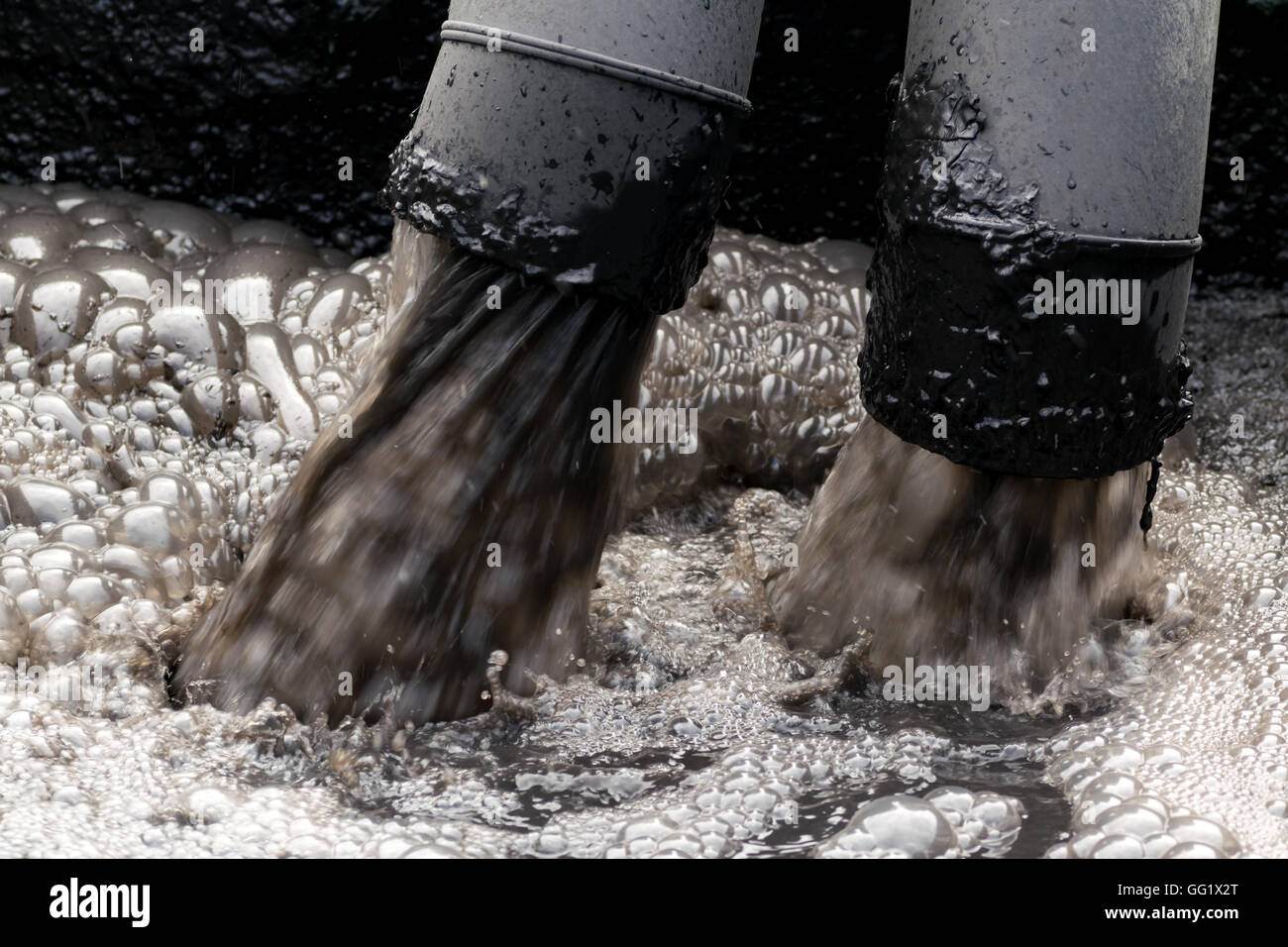 Inquinamento di acqua nel fiume perché non industriali trattare l' acqua prima dello scarico. Foto Stock