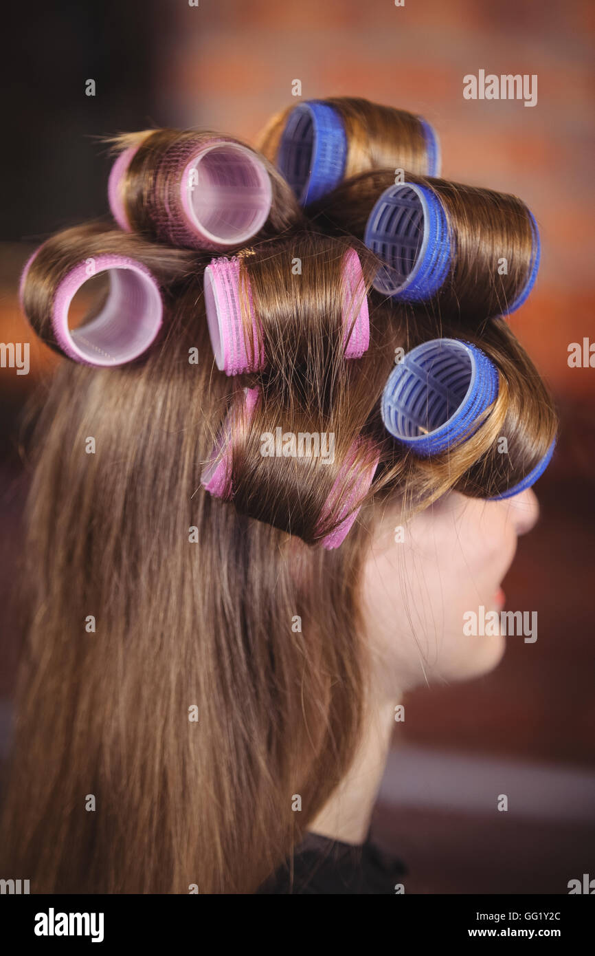Donna con rullo di capelli su capelli Foto Stock