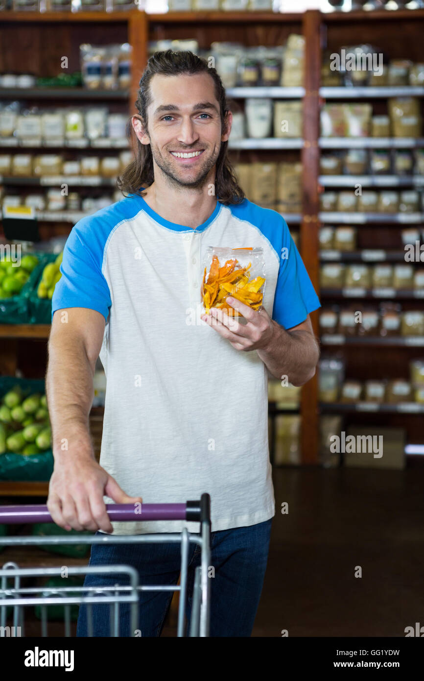 Uomo con voce di generi alimentari con carrello della spesa Foto Stock