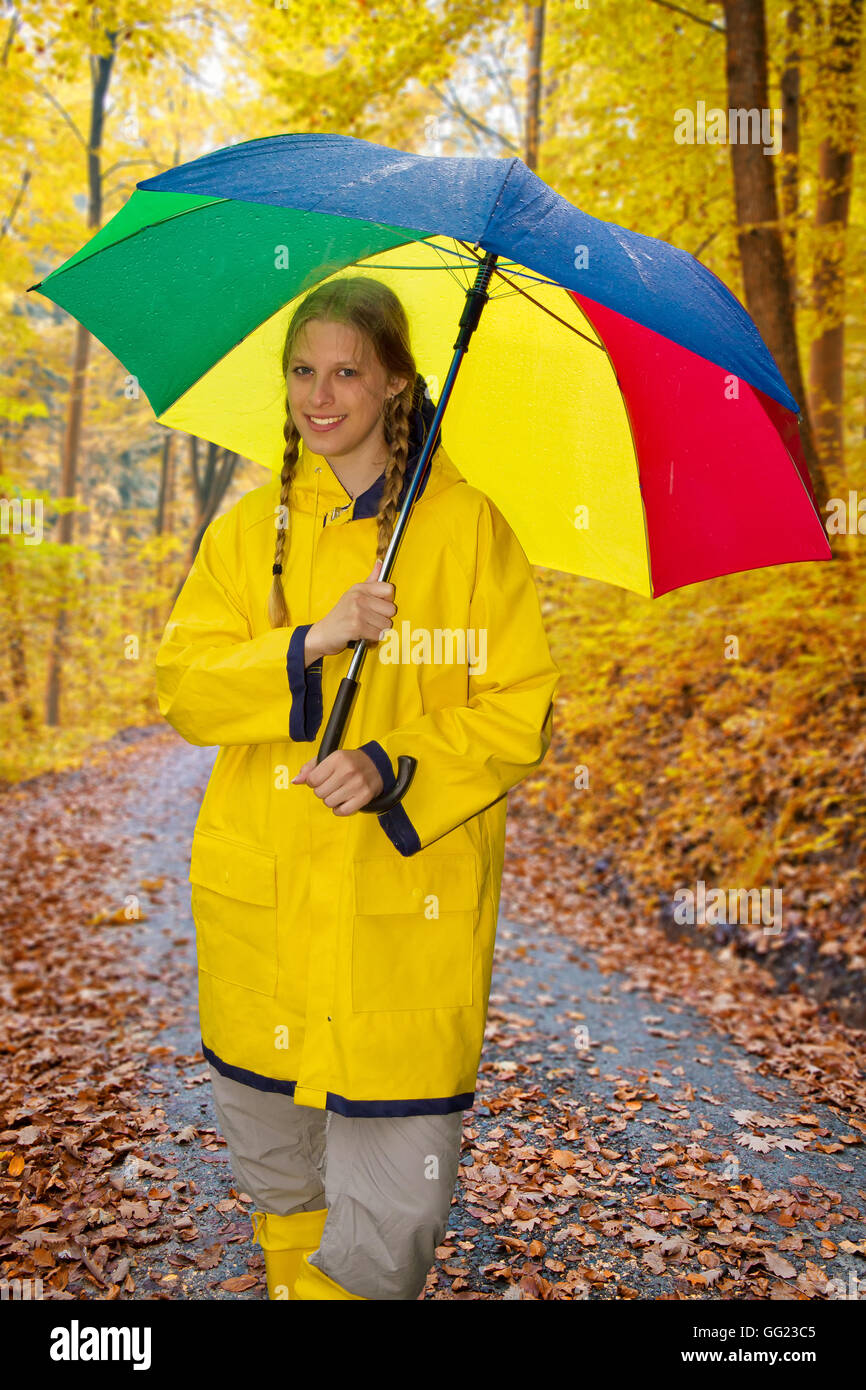 Giovane donna con umbrealla in una foresta di autunno Foto Stock