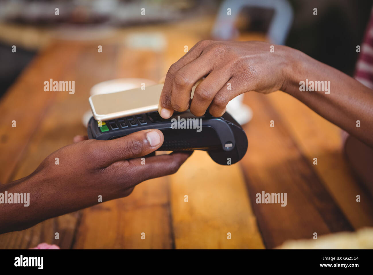 La donna il pagamento fattura tramite lo smartphone utilizzando la tecnologia NFC Foto Stock
