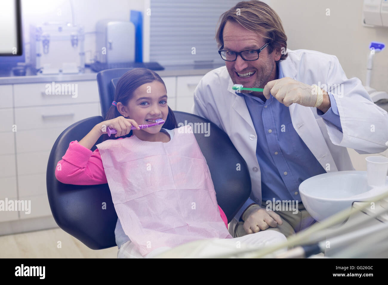 Dentista sorridente e paziente lavarsi i denti Foto Stock