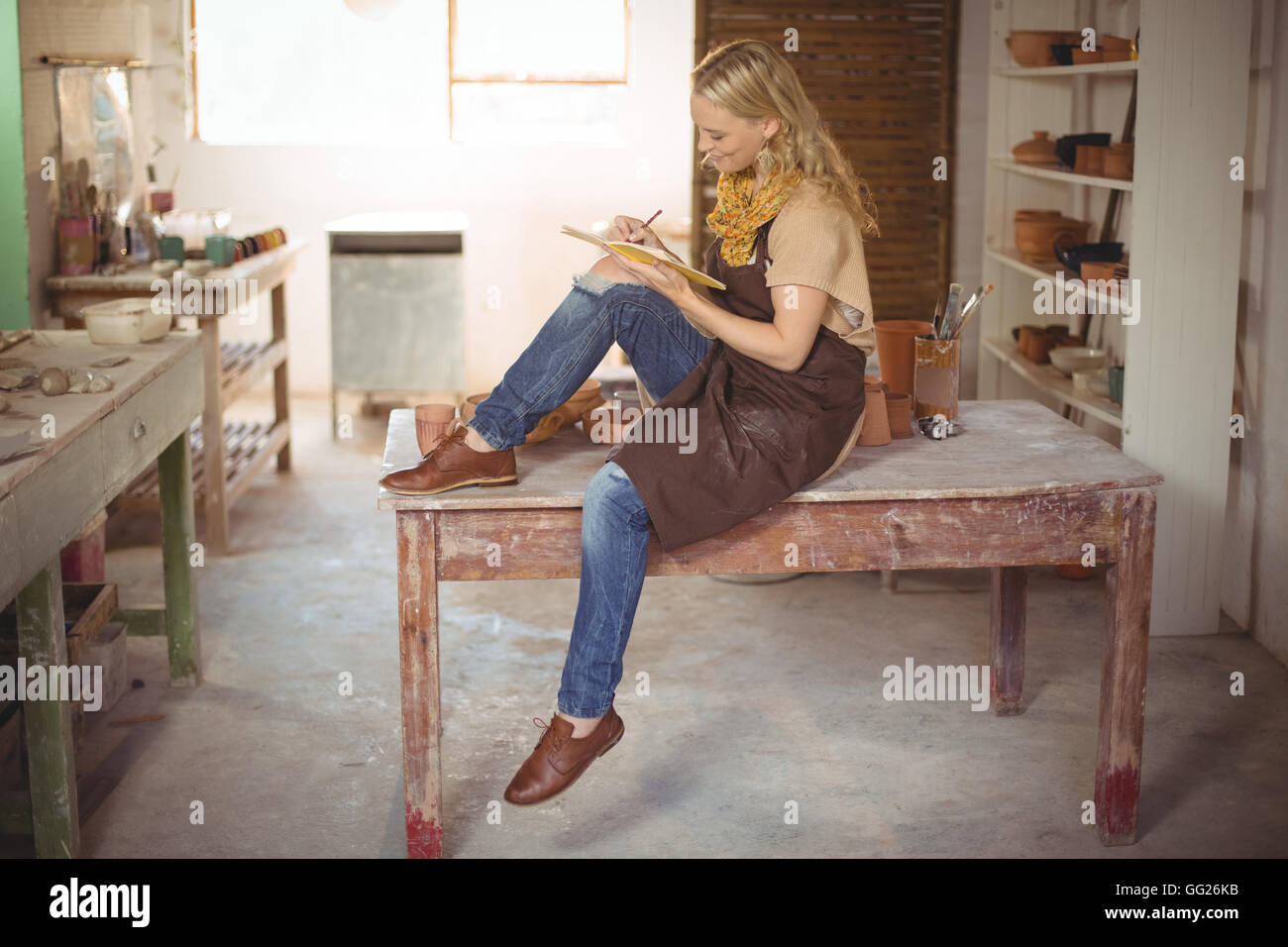 Bellissima femmina potter iscritto nel notebook Foto Stock