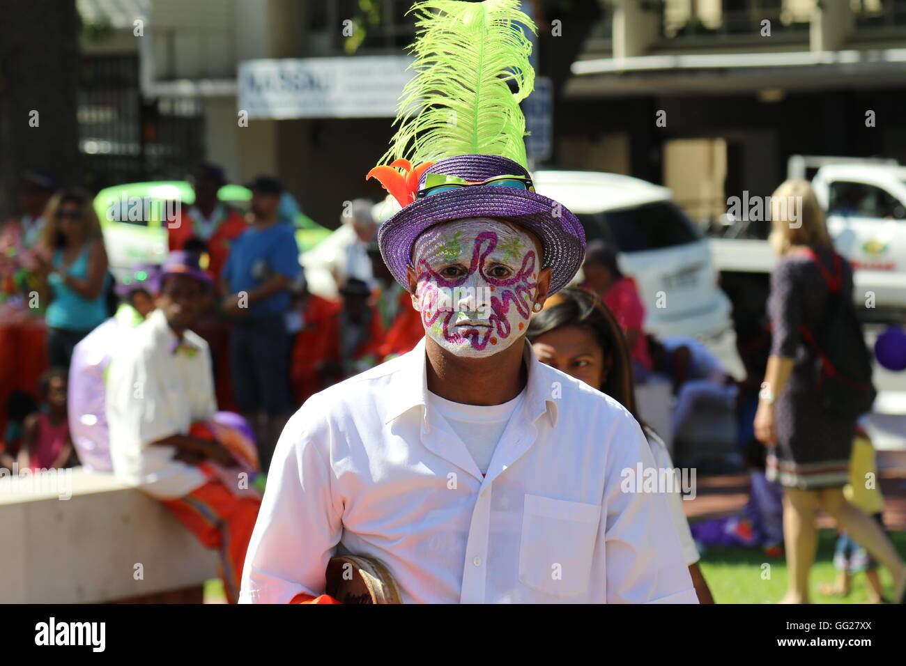 Un uomo con la faccia di vernice e un cappello piumato al 2016 Stellenbosch wine parade Foto Stock