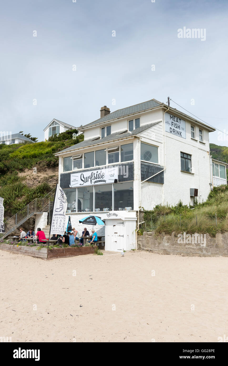 Il Surfside beach cafe e ristorante sulla spiaggia a Polzeath Cornwall Regno Unito con persone mangiare a tavoli esterni Foto Stock