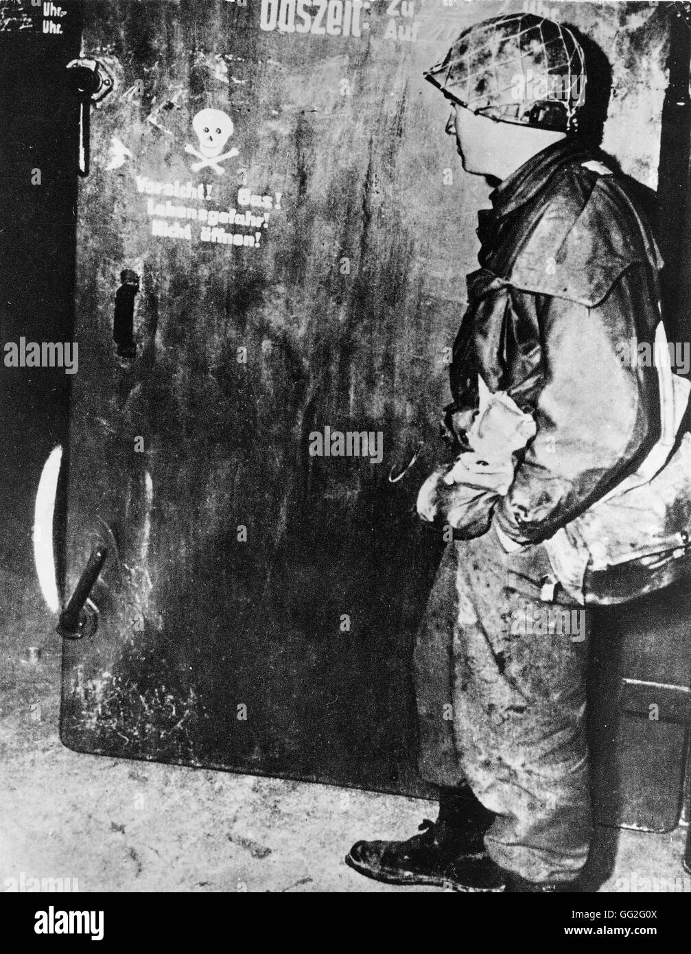 Soldato americano prima di una camera del gas porta in un campo di concentramento nazista. 1945 Foto Stock