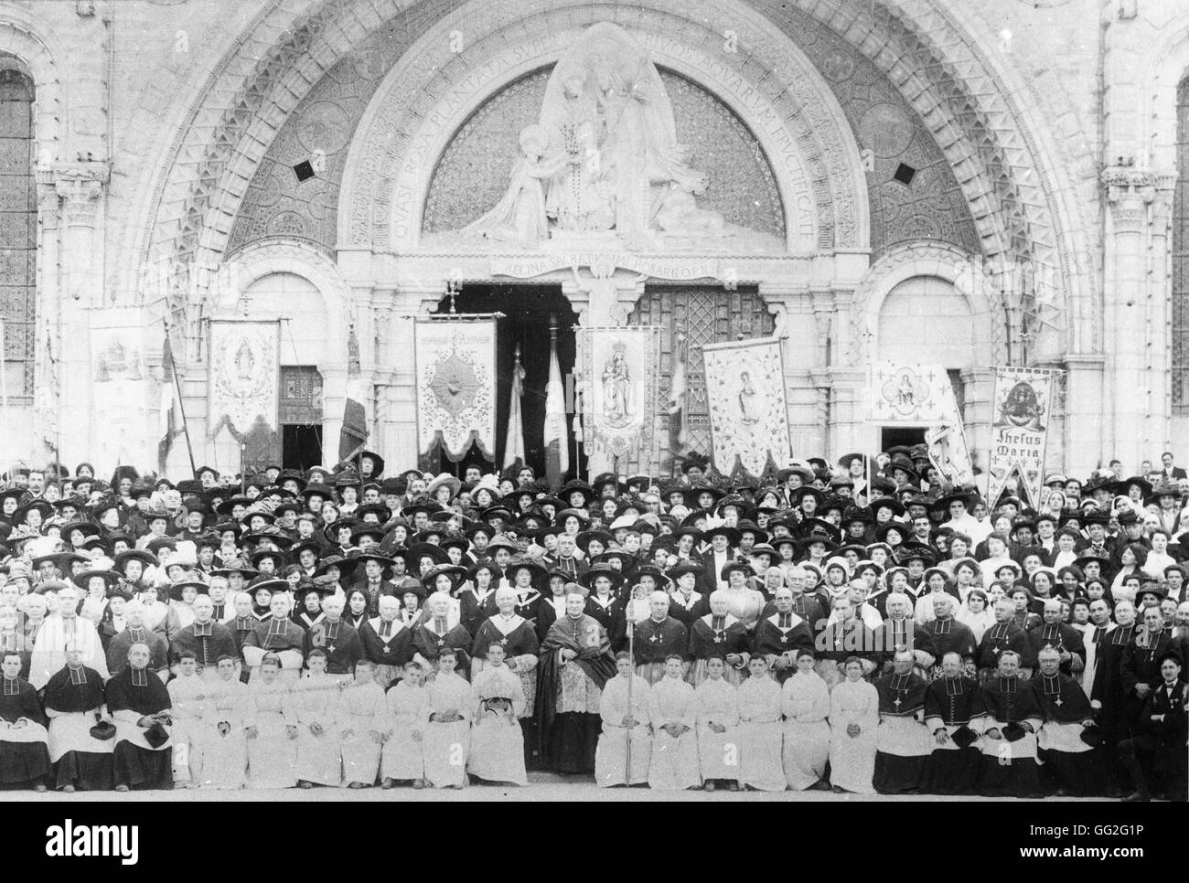 Pellegrini in posa davanti alla Cattedrale di Notre Dame de Lourdes (Nostra Signora di Lourdes). Giugno 1912 Foto Stock