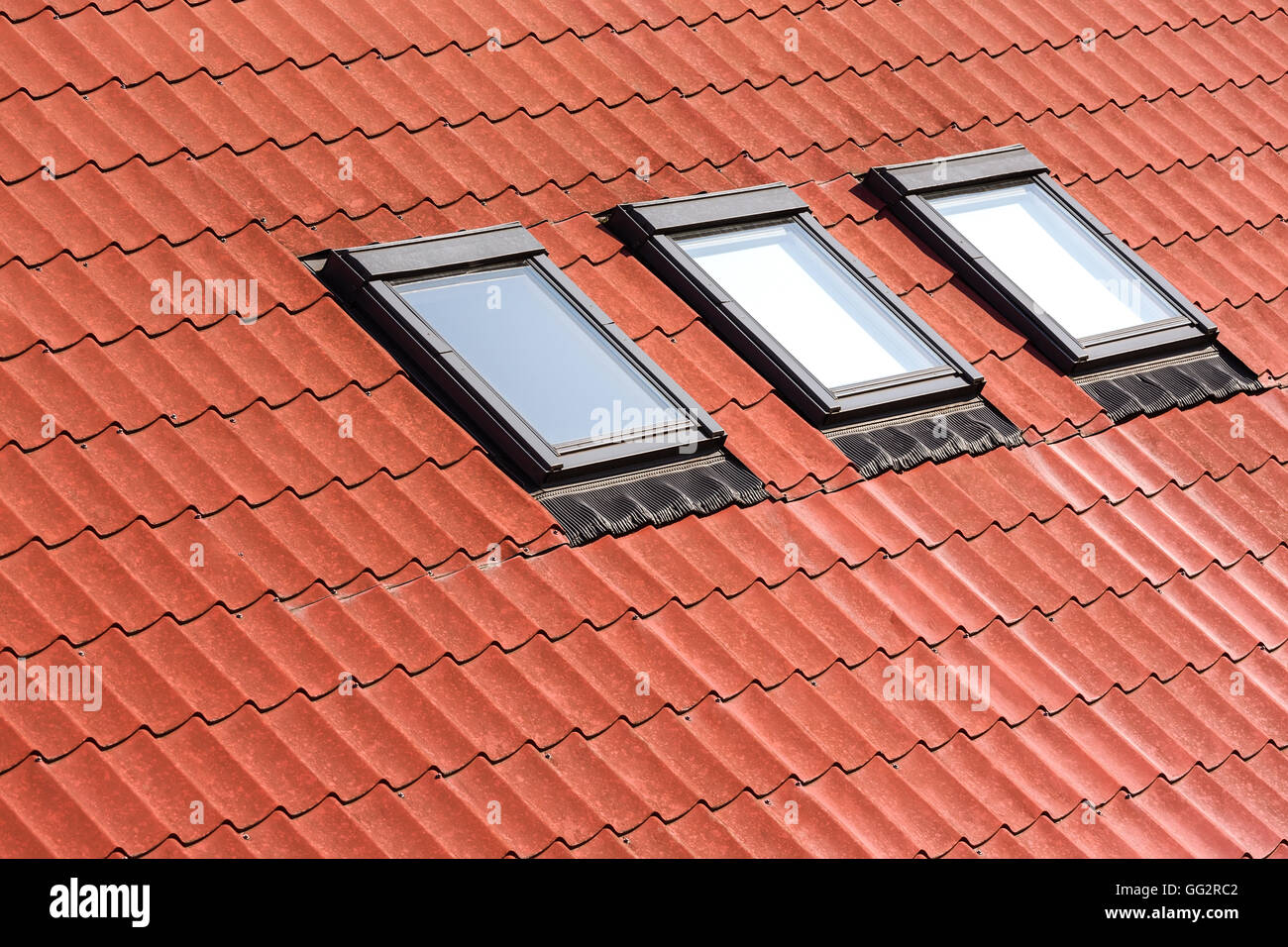 Arancione moderno tetto di tegole con tre lucernari Foto Stock