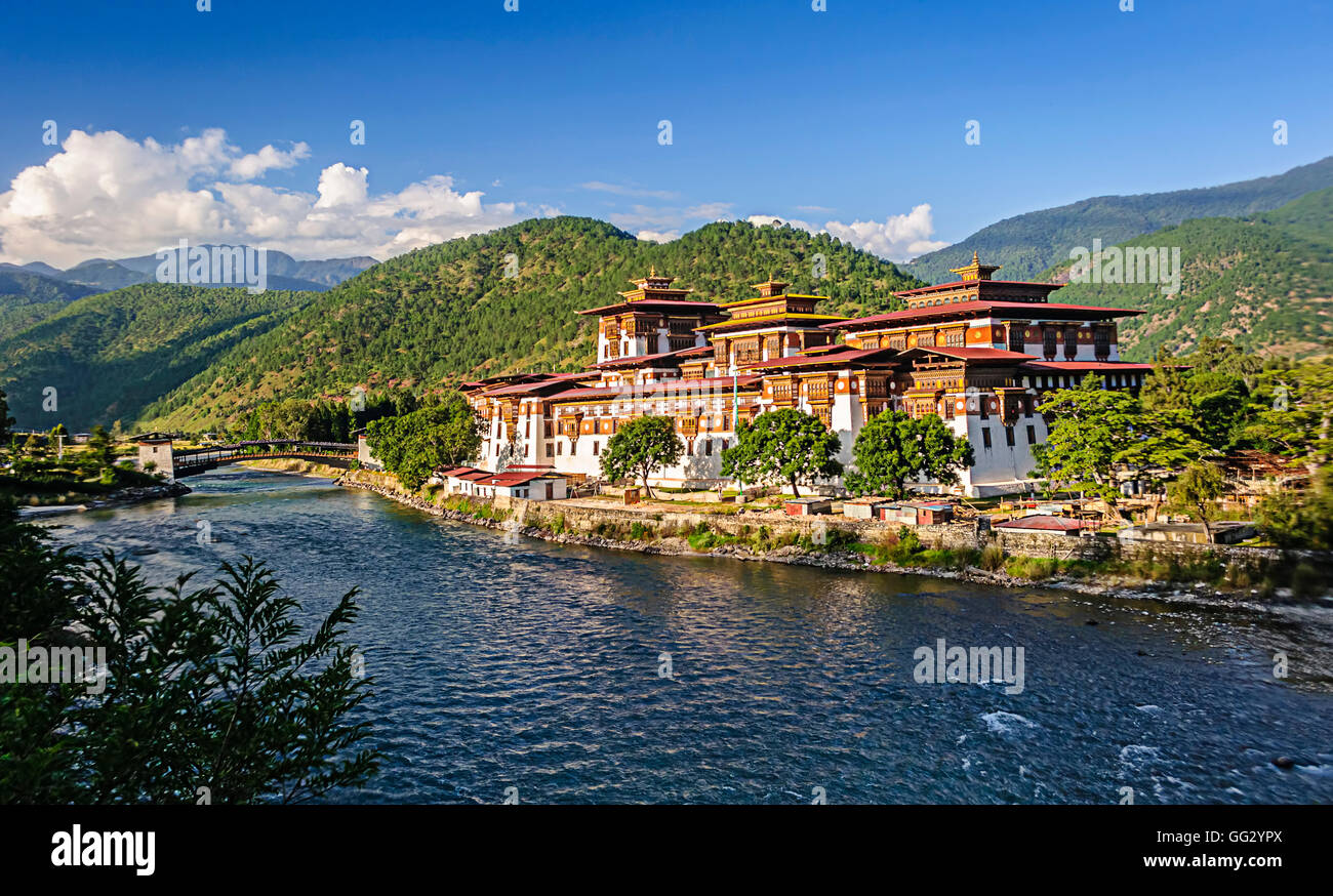 Punakha Dzong, fortezza del Bhutan, alla confluenza di due scorre il fiume blu e sfondo di verdi montagne himalayane, spazio di copia Foto Stock