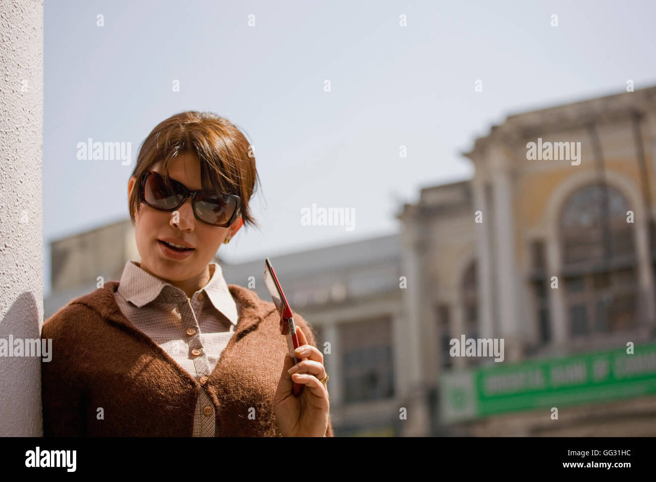 Donna in possesso di un telefono cellulare Foto Stock