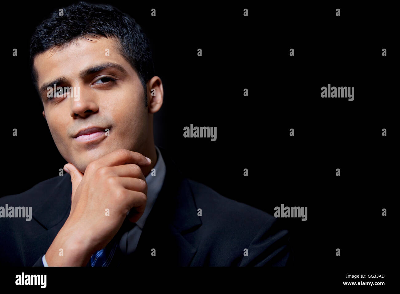 Fiducioso giovane uomo d affari su sfondo nero Foto Stock