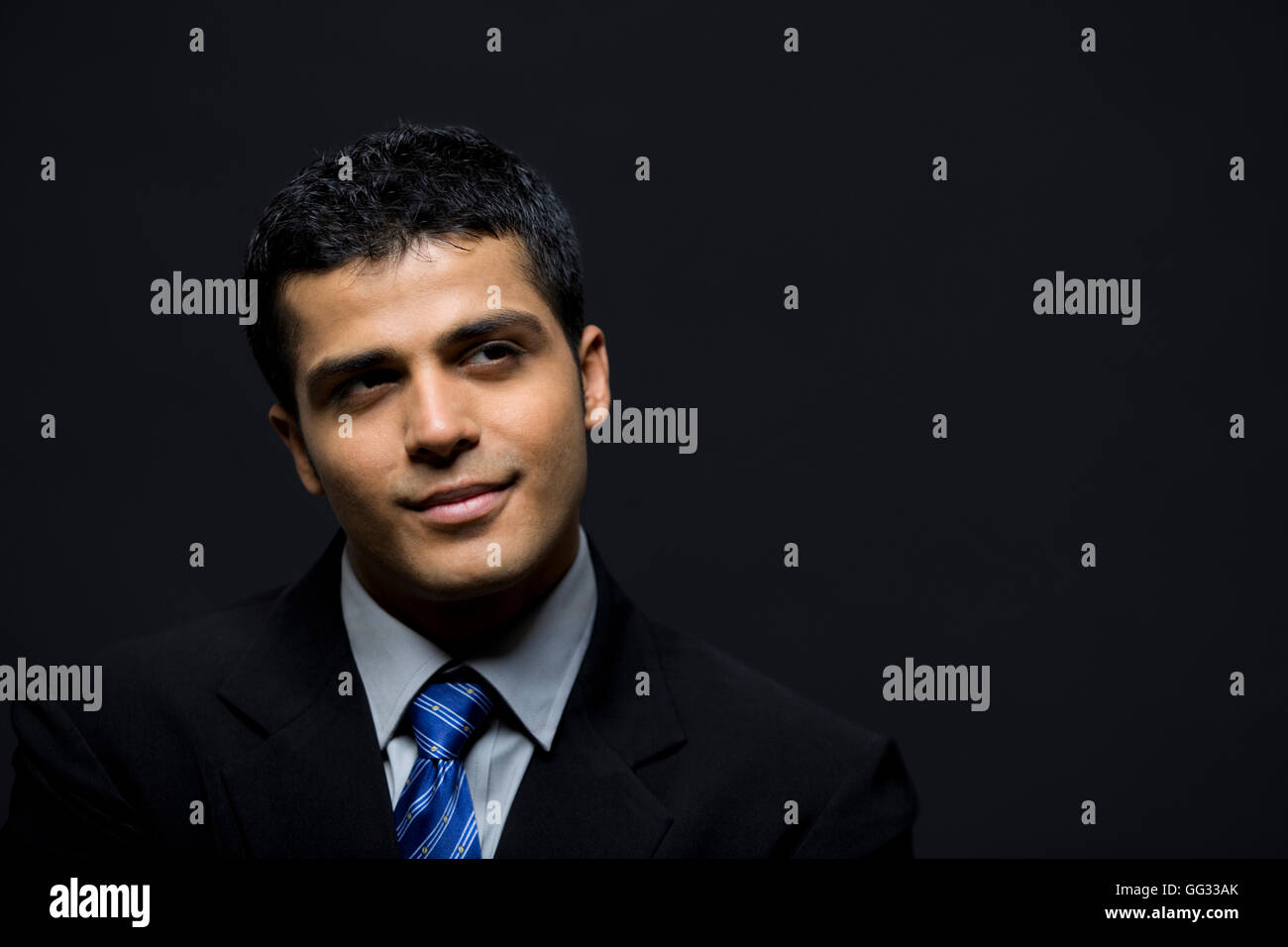 Happy businessman contemplando su sfondo nero Foto Stock