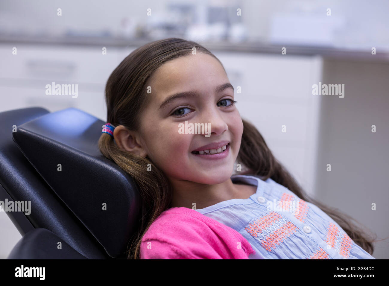 Sorridente giovane paziente seduto sulla sedia dentisti Foto Stock