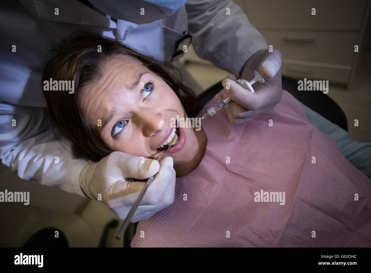 Dentista iniettando il paziente di sesso femminile Foto Stock