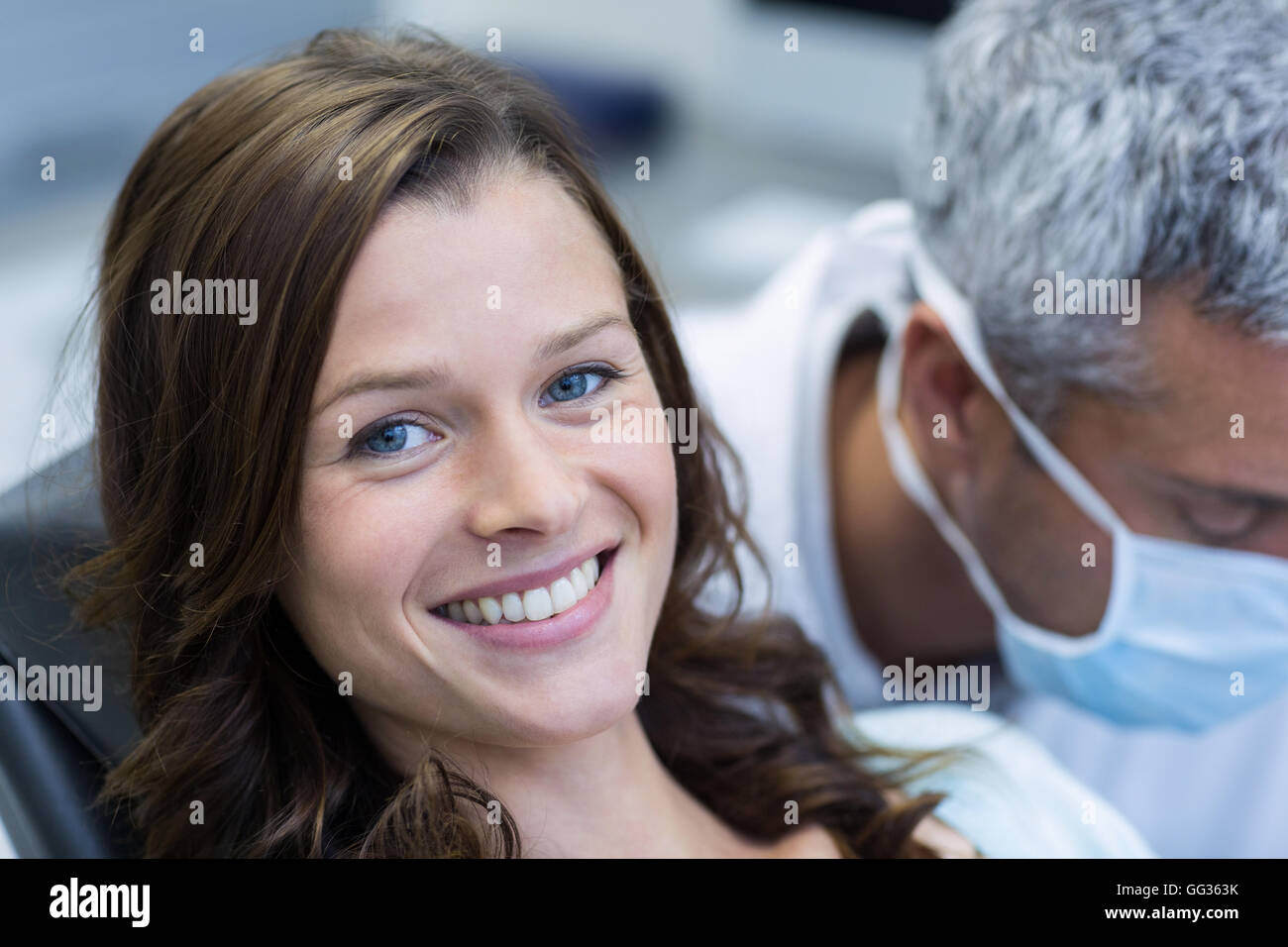 Sorridente paziente seduto sulla poltrona del dentista Foto Stock