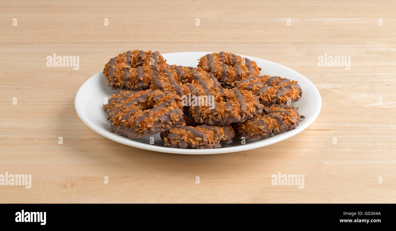 Diversi fudge con noce di cocco e caramello i cookie su una piastra bianca in cima a una tavola di legno. Foto Stock