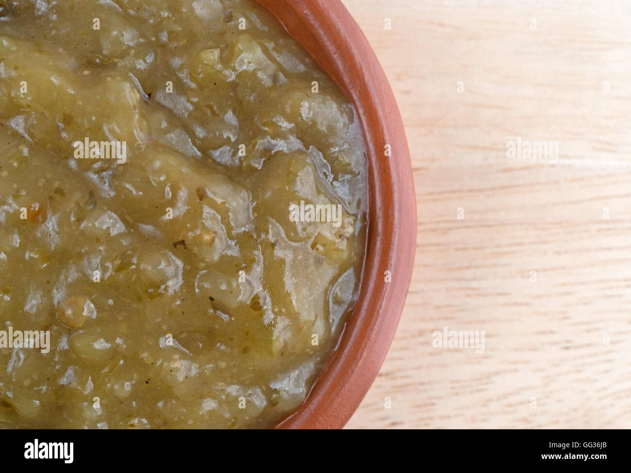 Top vista ravvicinata di una ciotola di culantro salsa di cottura su una tavola di legno. Foto Stock