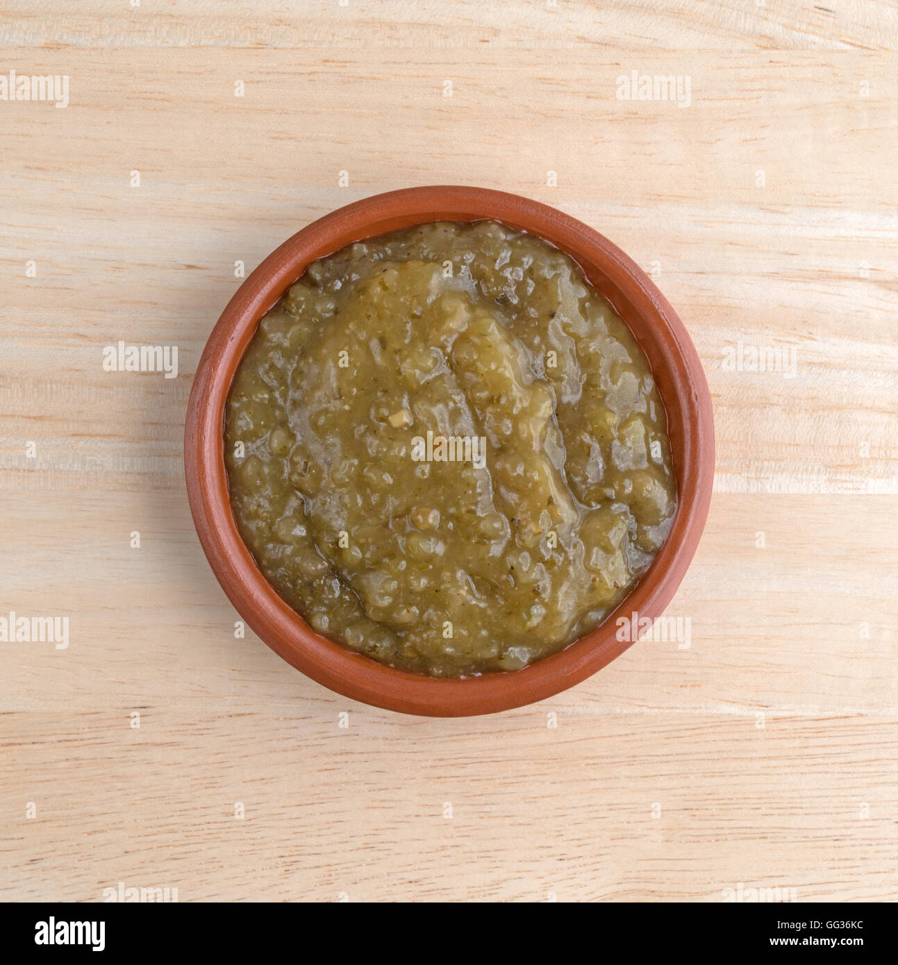 Vista dall'alto di una ciotola di culantro salsa di cottura su una tavola di legno. Foto Stock