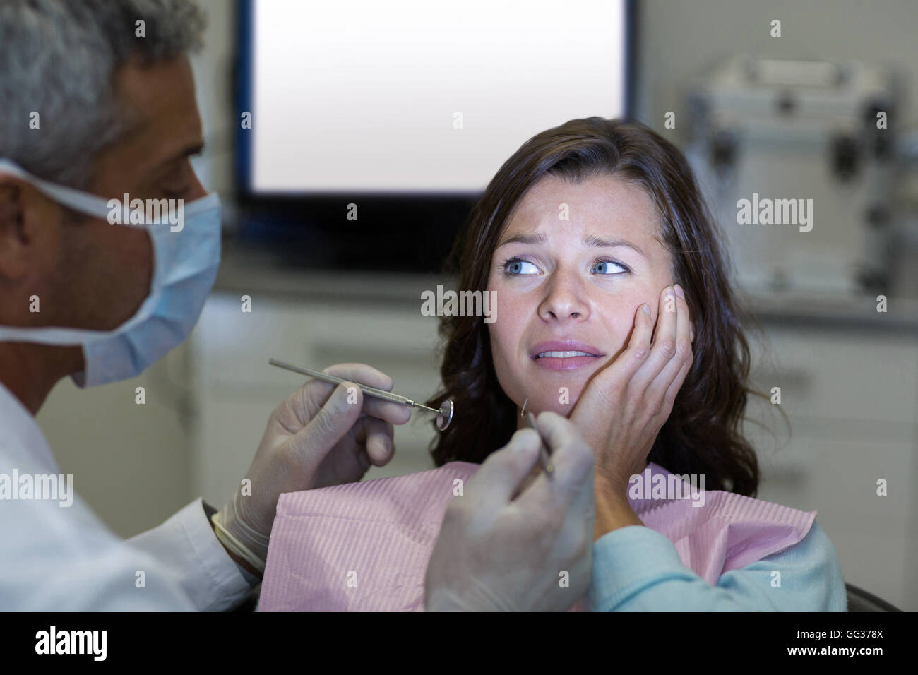 Dentista di esame di un paziente femmina con strumenti Foto Stock