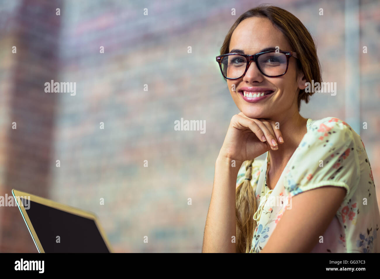 Sorridente business executive con mano sul mento in ufficio Foto Stock