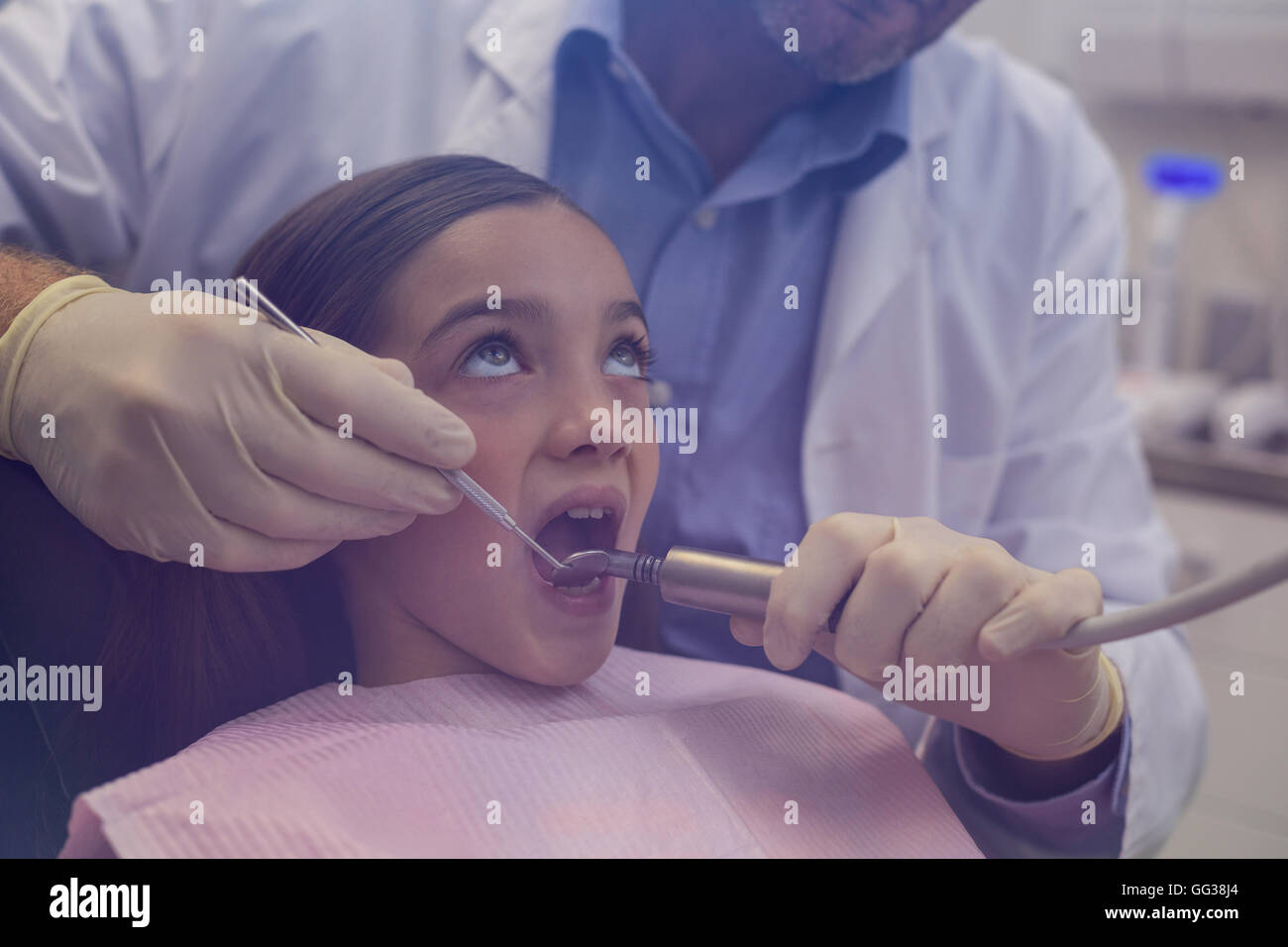 Dentista esaminando un paziente giovane con strumenti Foto Stock