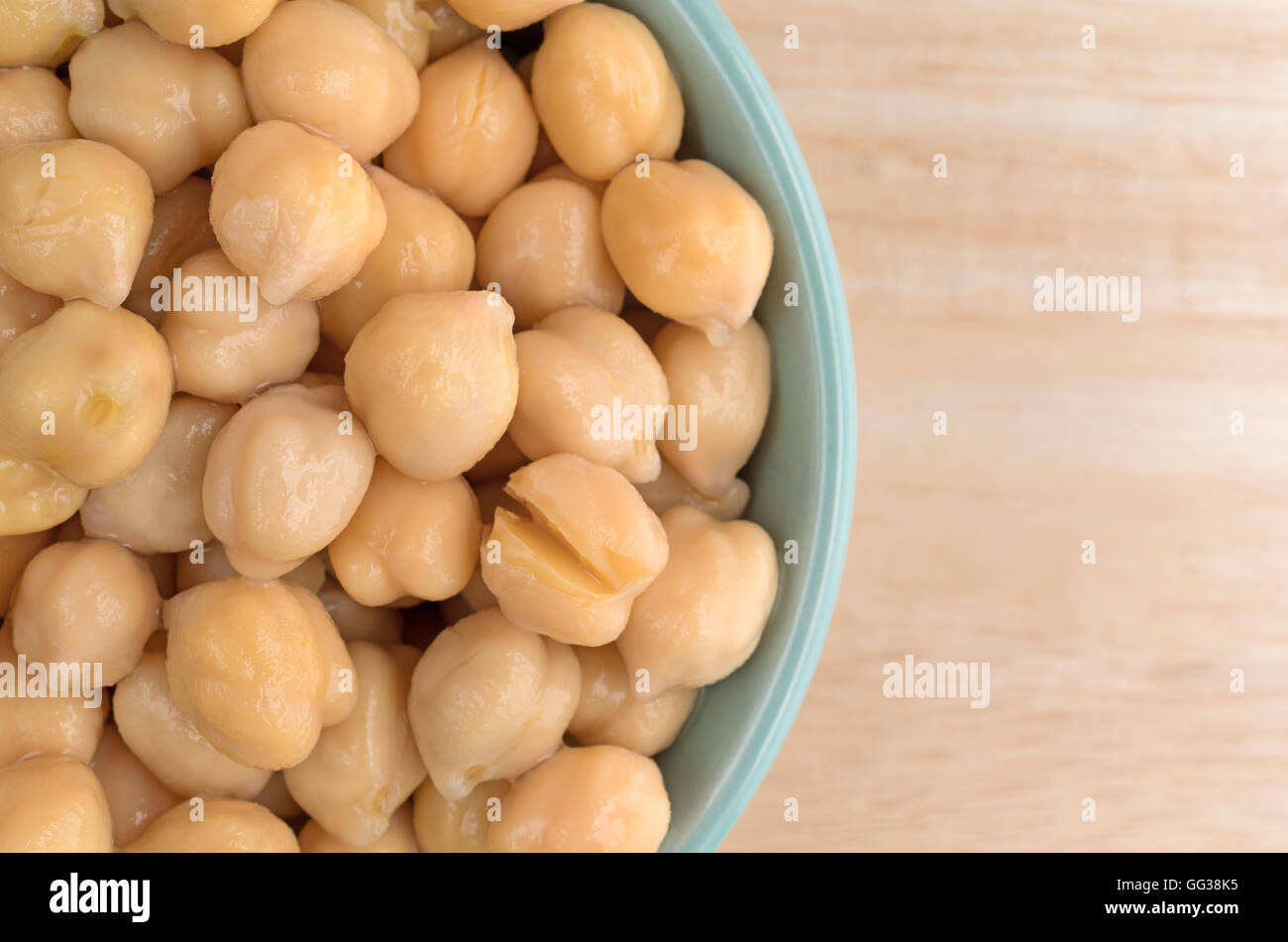 Top vista ravvicinata di una ciotola riempita con organici i ceci su una tavola di legno. Foto Stock