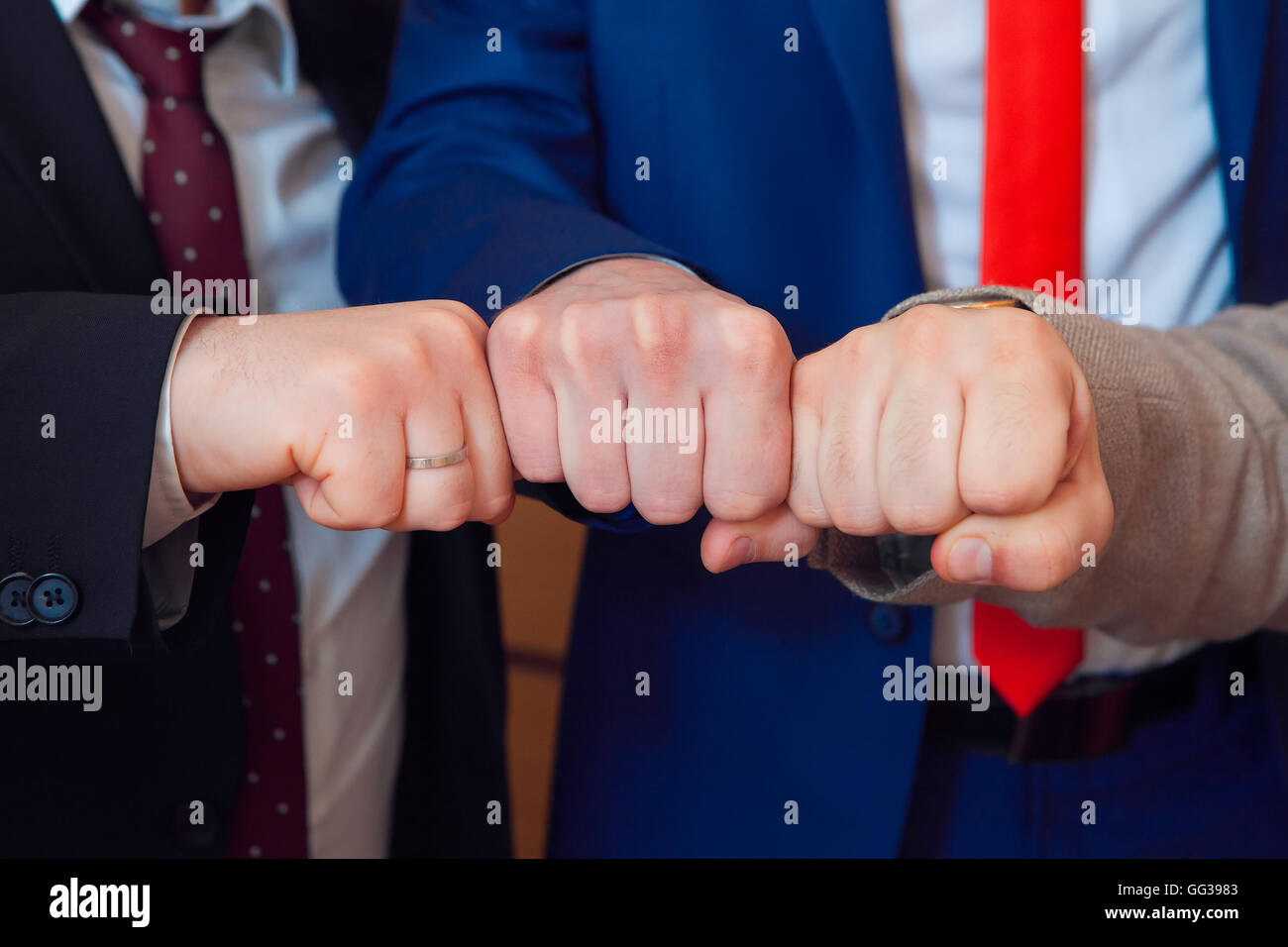 Pugno tre amici dello sposo e della sposa con anello di nozze Foto Stock