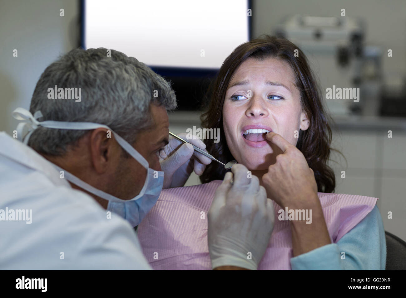 Dentista di esame di un paziente femmina con strumenti Foto Stock