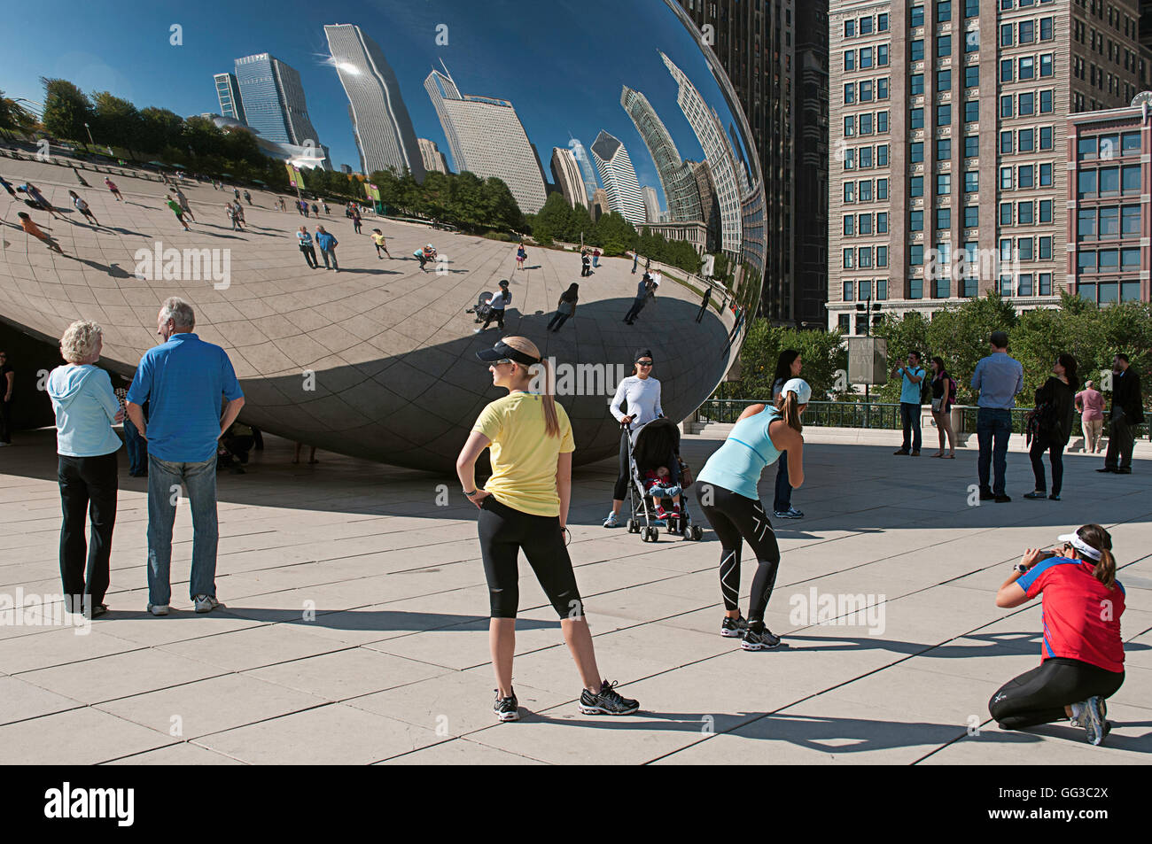 Le persone che posano per una foto di fronte al Cloud Gate (il bean) in Millennium Park, Chicago, Illinois marathon weekend. Foto Stock