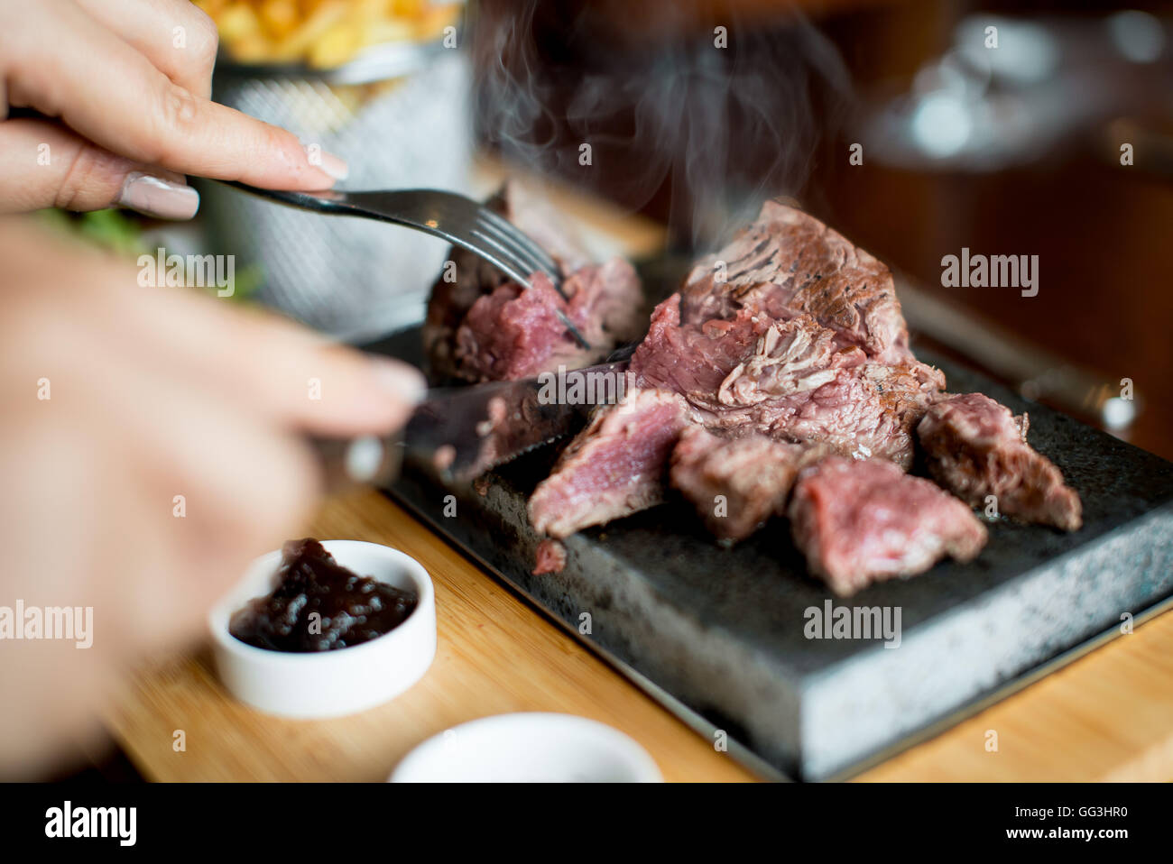 Costata di manzo cucinati e tagliati su una pietra calda in un ristorante Foto Stock