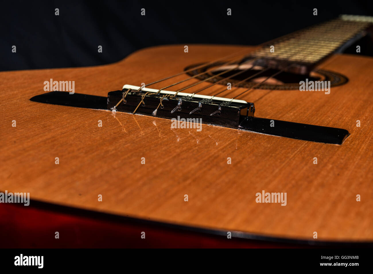 Approccio ad un detali della chitarra spagnola su sfondo nero Foto Stock