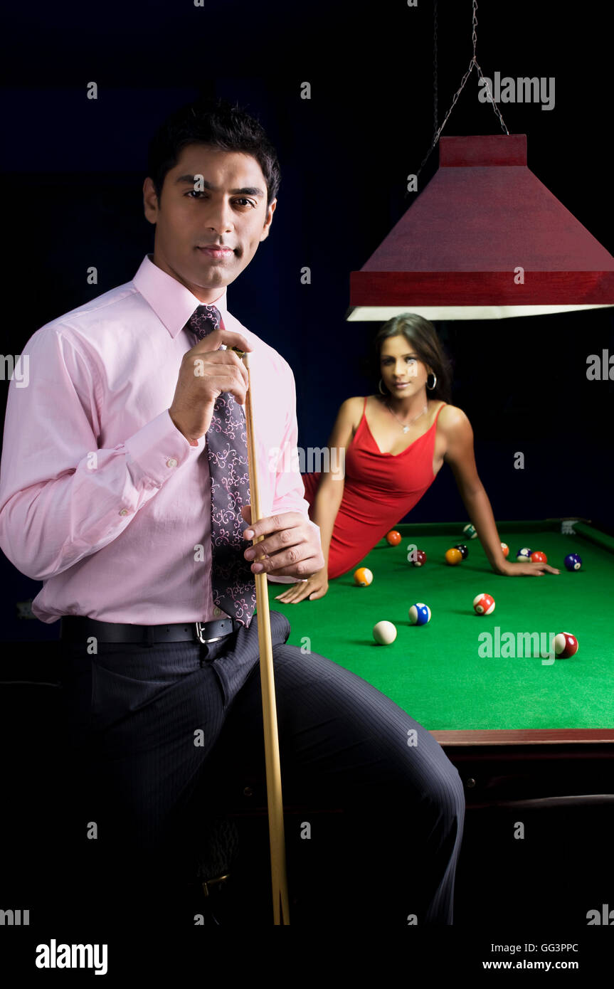 Uomo con cue stick in posa Foto Stock