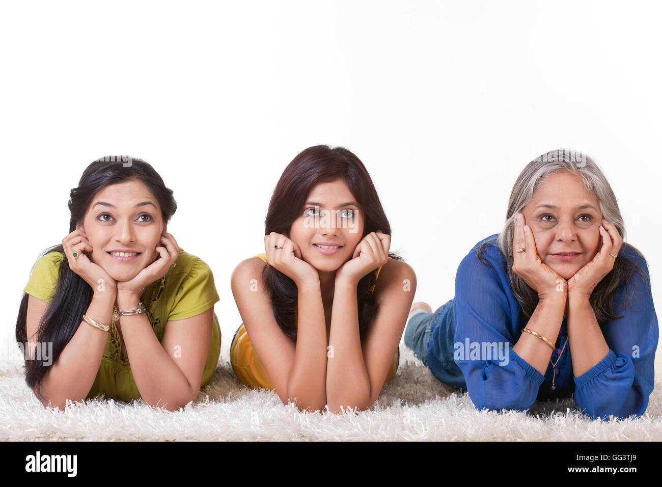 Ragazza con sua madre e nonna giacente su un tappeto Foto Stock