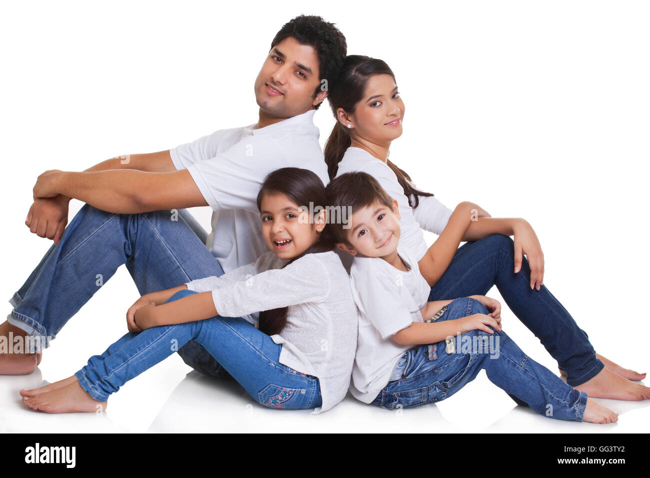 Ritratto di famiglia felice seduto su sfondo bianco Foto Stock