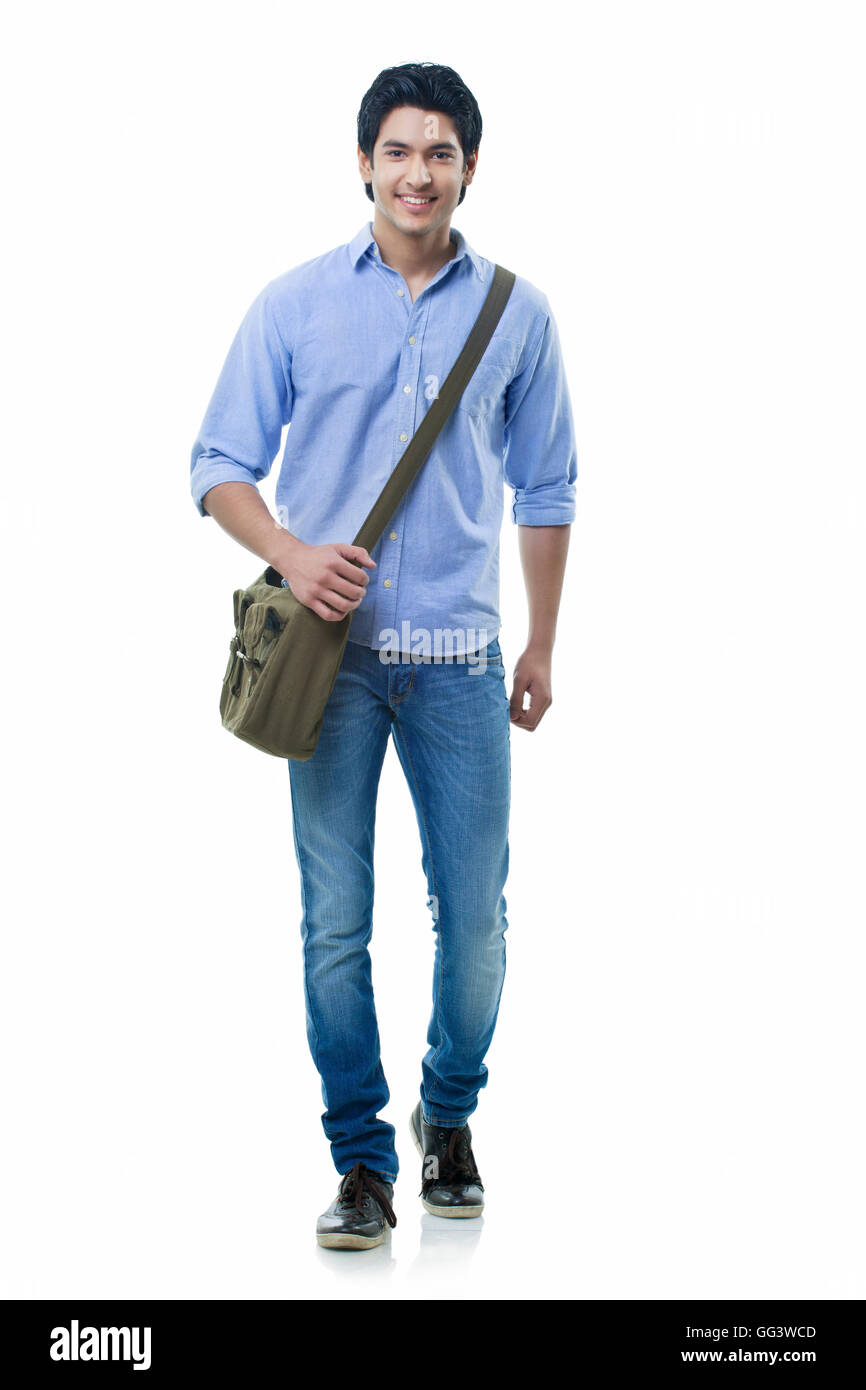Sorridente giovane uomo camminare su sfondo bianco Foto Stock