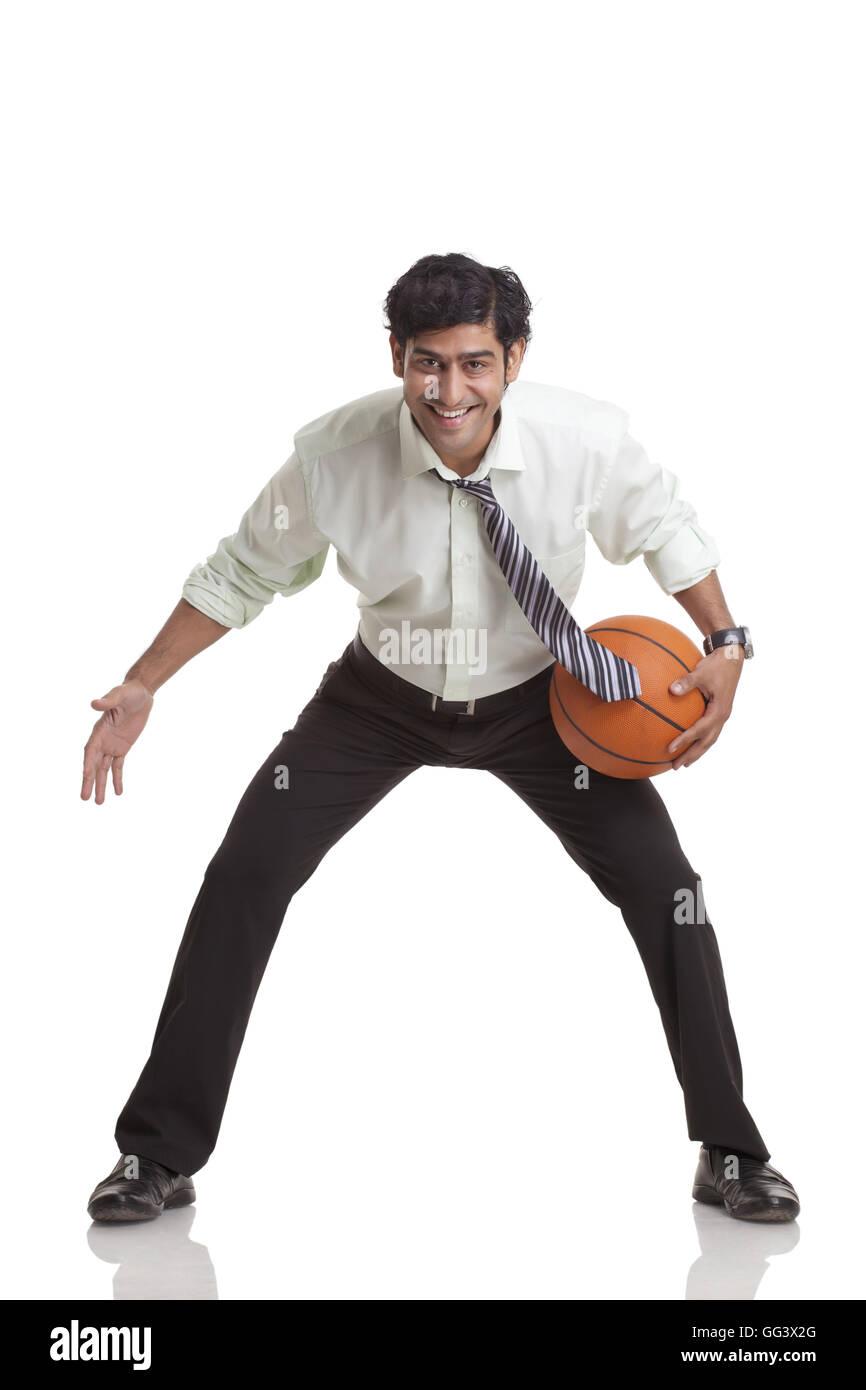 Ritratto di giovane sorridente imprenditore giocare a basket Foto Stock