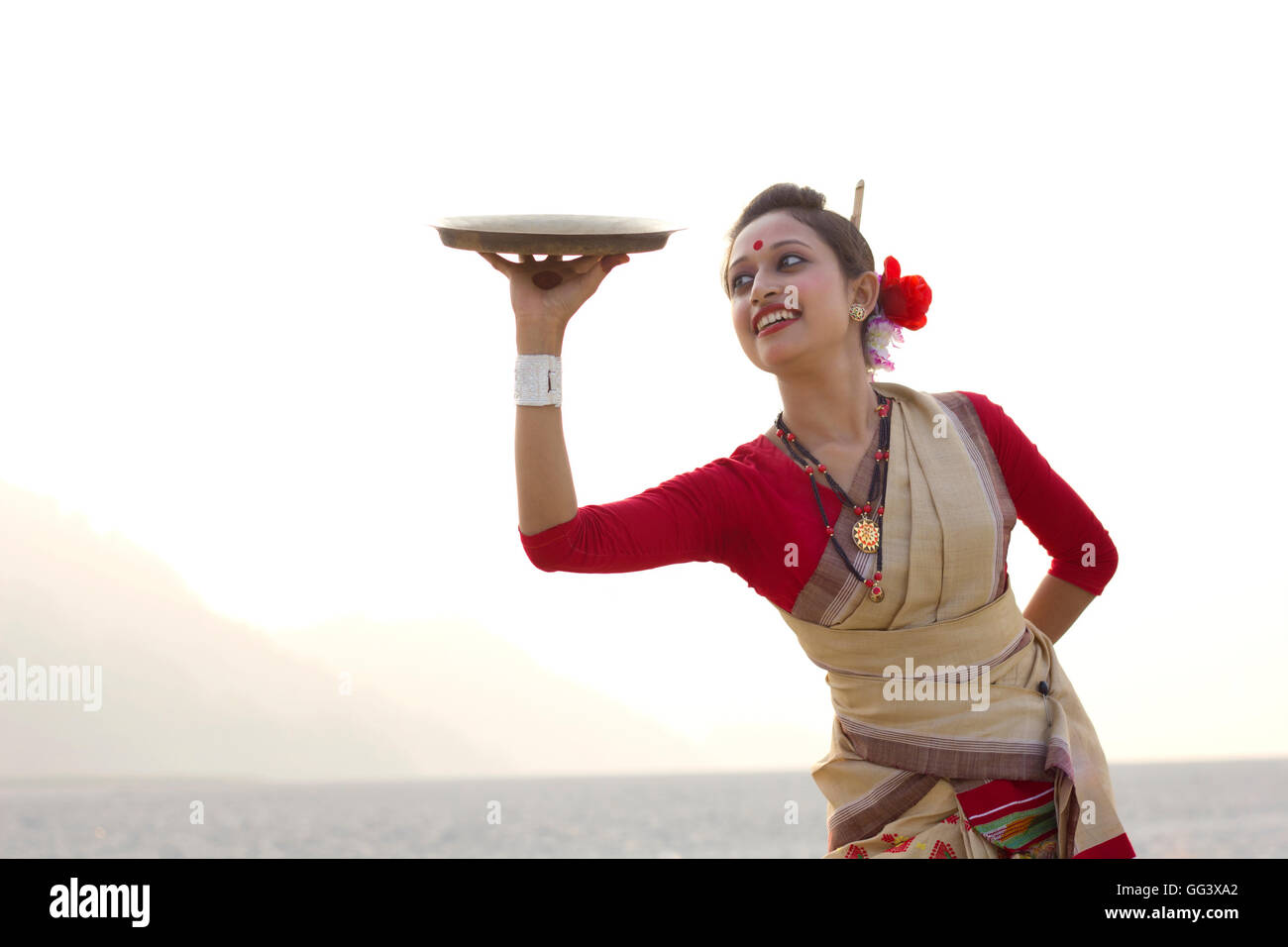 Bihu woman dancing con una lastra di ottone Foto Stock