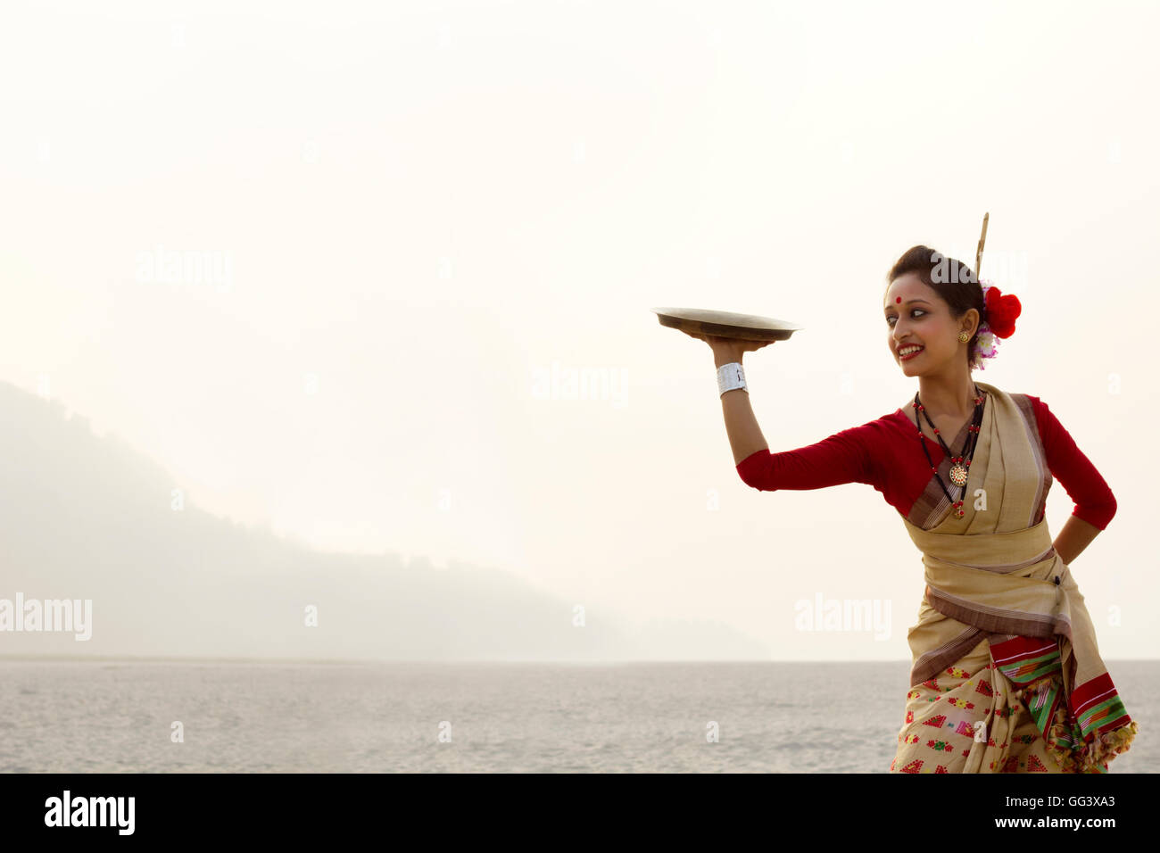 Bihu woman dancing con una lastra di ottone Foto Stock