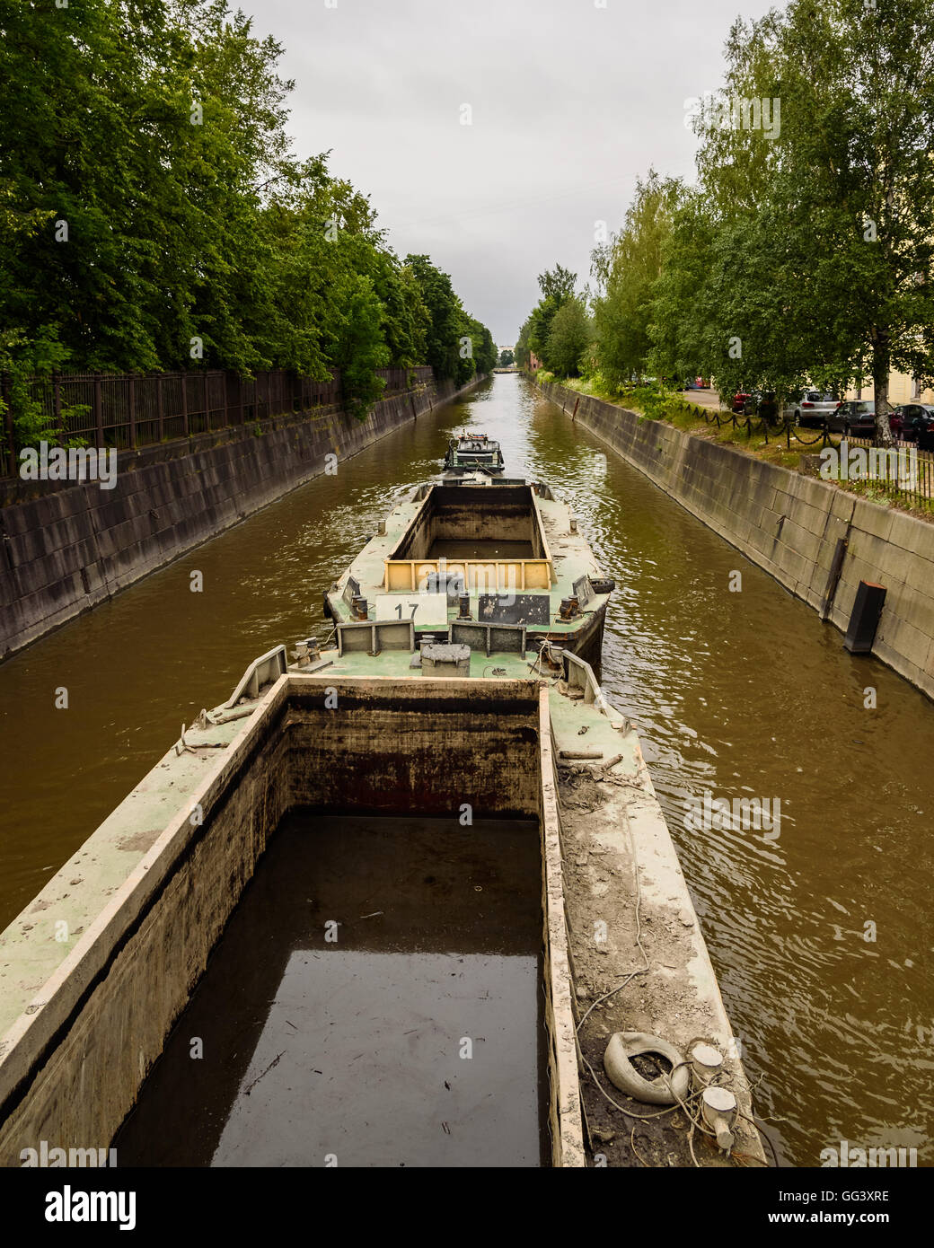 Barge in movimento lungo il canale per le riparazioni su un giorno nuvoloso Foto Stock