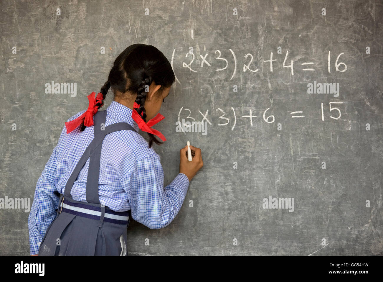 Scuola rurale ragazza scrivere sulla scheda Foto Stock