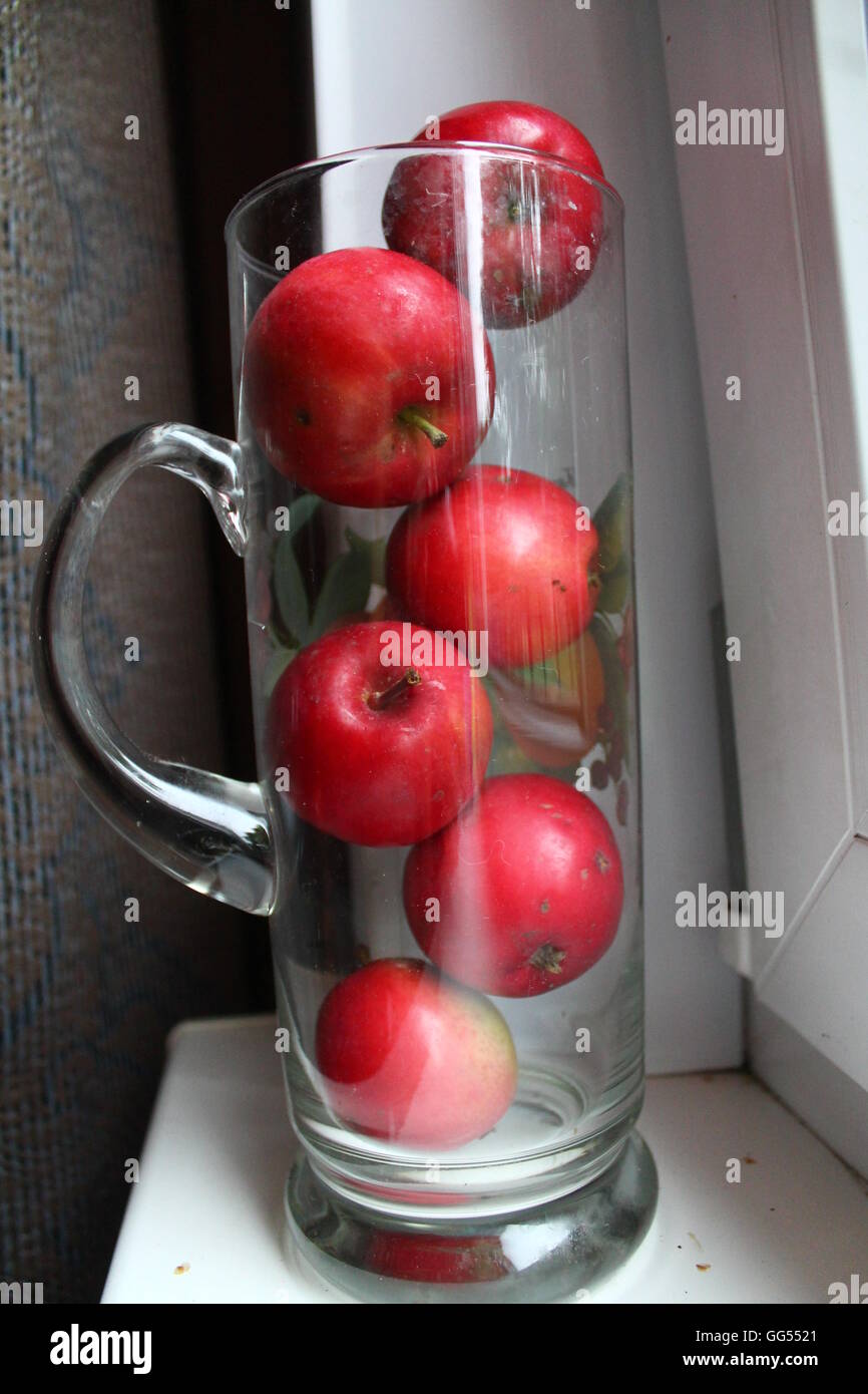 Bella rossa succosa mele dolci nella brocca di vetro bella luce estate dessert e decorazione per la casa Foto Stock